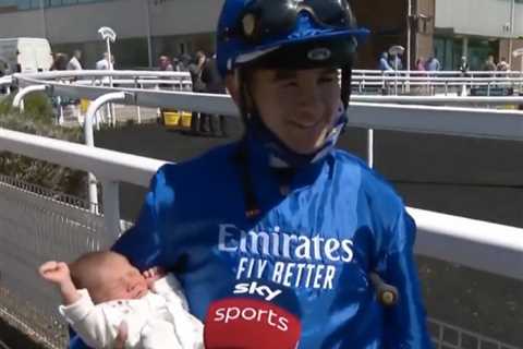 Jockey Marco Ghiani delicately holds 15-DAY-old son Louis as he celebrates riding a winner at..