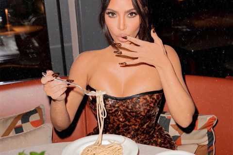 Kim Kardashian shows off long legs in super short mini-dress before she chows down on pasta dinner..