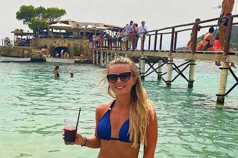 Dani Dyer sips on sangria in a blue bikini before slipping into another swimsuit on holiday