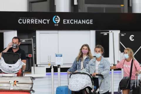Dani Dyer keeps her head down as she returns to UK after family holiday with baby Santi as dad..