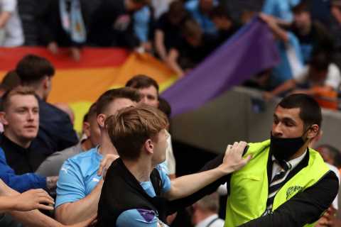 Man City fans clash with Spurs stewards inside stadium and try to climb over barricades after..