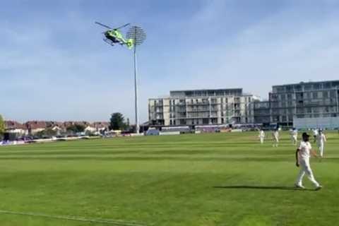Astonishing moment HELICOPTER lands on cricket pitch and stops play as air ambulance rushes to deal ..