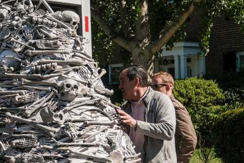 Activists take vaccine demands, and a mountain of fake bones, to the home of Biden’s chief of staff.