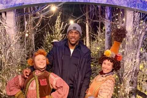 Anthony Joshua struggles to stay on feet while ice-skating and holds on to a penguin to stop him..
