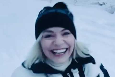 Holly Willoughby grins as she toboggans in the snow on holiday before Dancing on Ice launch