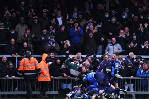 Adebayo Akinfenwa delights fans as he dances and then JUMPS on top of team-mates as Wycombe grab..