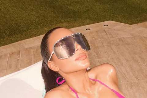 Kim Kardashian nearly pops out of a tiny pink bikini in oiled-up new photos after Bahamas getaway..