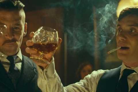 Why does Tommy Shelby lick his cigarette before smoking?