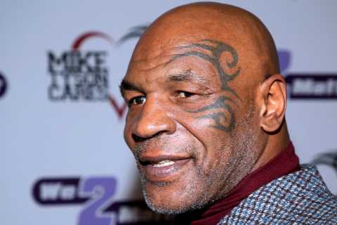 Mike Tyson laughs down phone in airport lounge just minutes after beating a fan on plane