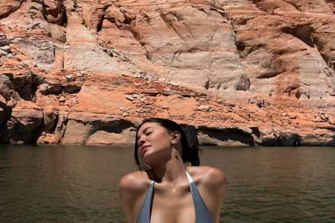 Kylie Jenner spills out of plunging swimsuit and dances with friends at boozy lake party after..