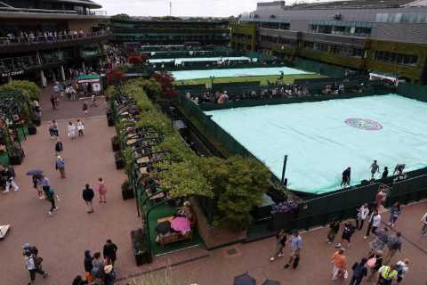 Wimbledon ALREADY suspended within first hour as rain pours and fans wait in soggy queue for..