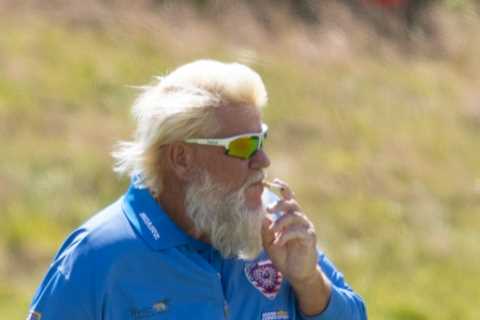 John Daly puffs cigarette while practicing for The Open after winning over fans with Past Champions ..