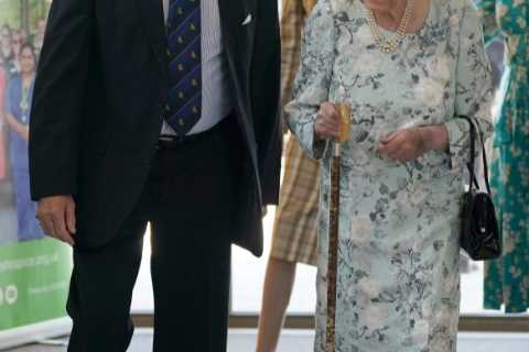 Queen, 96, beams in summer florals as she makes surprise visit to support hospice patients