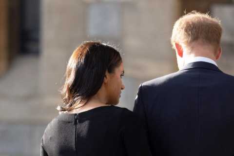 Sweet moment Meghan Markle comforts Prince Harry as he looks at floral tributes for the Queen