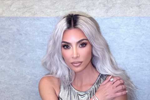 Kim Kardashian poses in just a silver bodysuit &amp; thigh-high boots in sexy new photos after her..