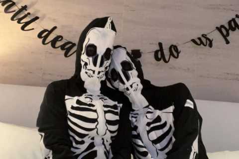 Kourtney Kardashian poses in bed with Travis Barker as they wear matching costumes after fans slam..