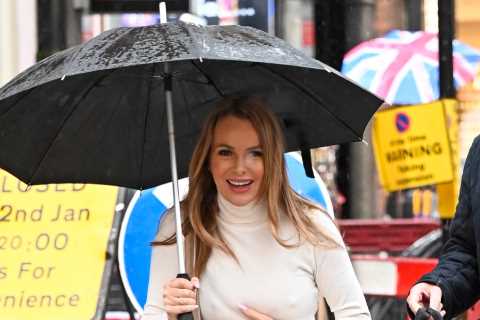 Amanda Holden goes braless and grabs her chest as she’s caught in the rain in London