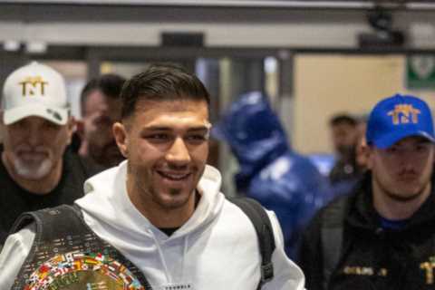 Bruised Tommy Fury beams as he touches down at Heathrow with brother Tyson and dad John after huge..