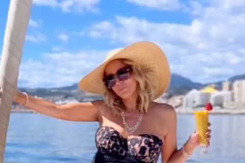 A Place In The Sun’s Jasmine Harman strips off to strapless leopard print swimsuit as she sips a..