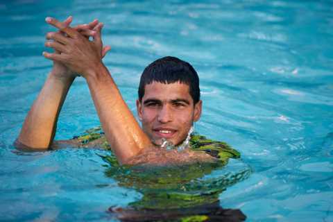 Watch tennis star Carlos Alcaraz dive into pool along with screaming ball girls after winning..