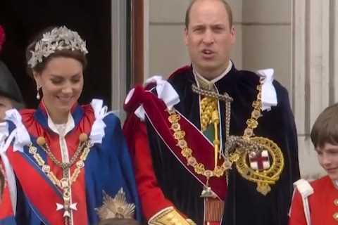Adorable moment Prince Louis leans over to chat to big brother George as they brave rain on..