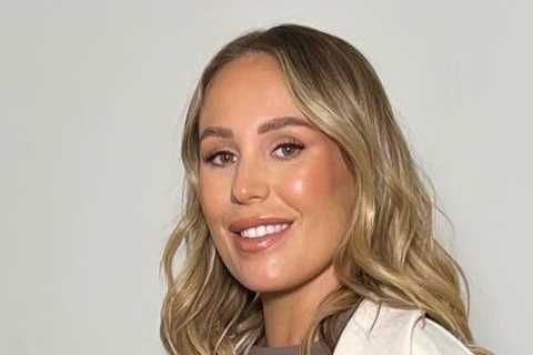 Kate Ferdinand shows off her huge baby bump in skintight dress as she struggles taking her boots off