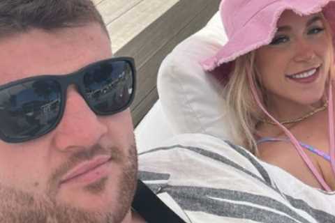 Elle Brooke relaxes in bikini in Magaluf then bursts into laughter as her huge boxer pal is..