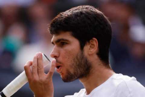 Why do tennis players like Carlos Alcaraz blow on their fingers and hands?